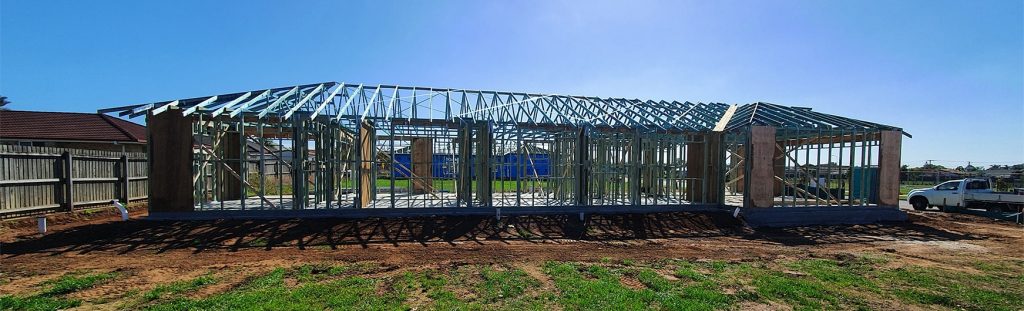 Construction of a new residential building with the framework in place on a clear day.