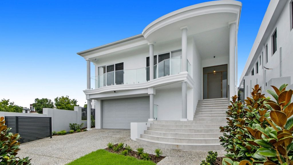 Modern two-story home with a balcony and a double garage.